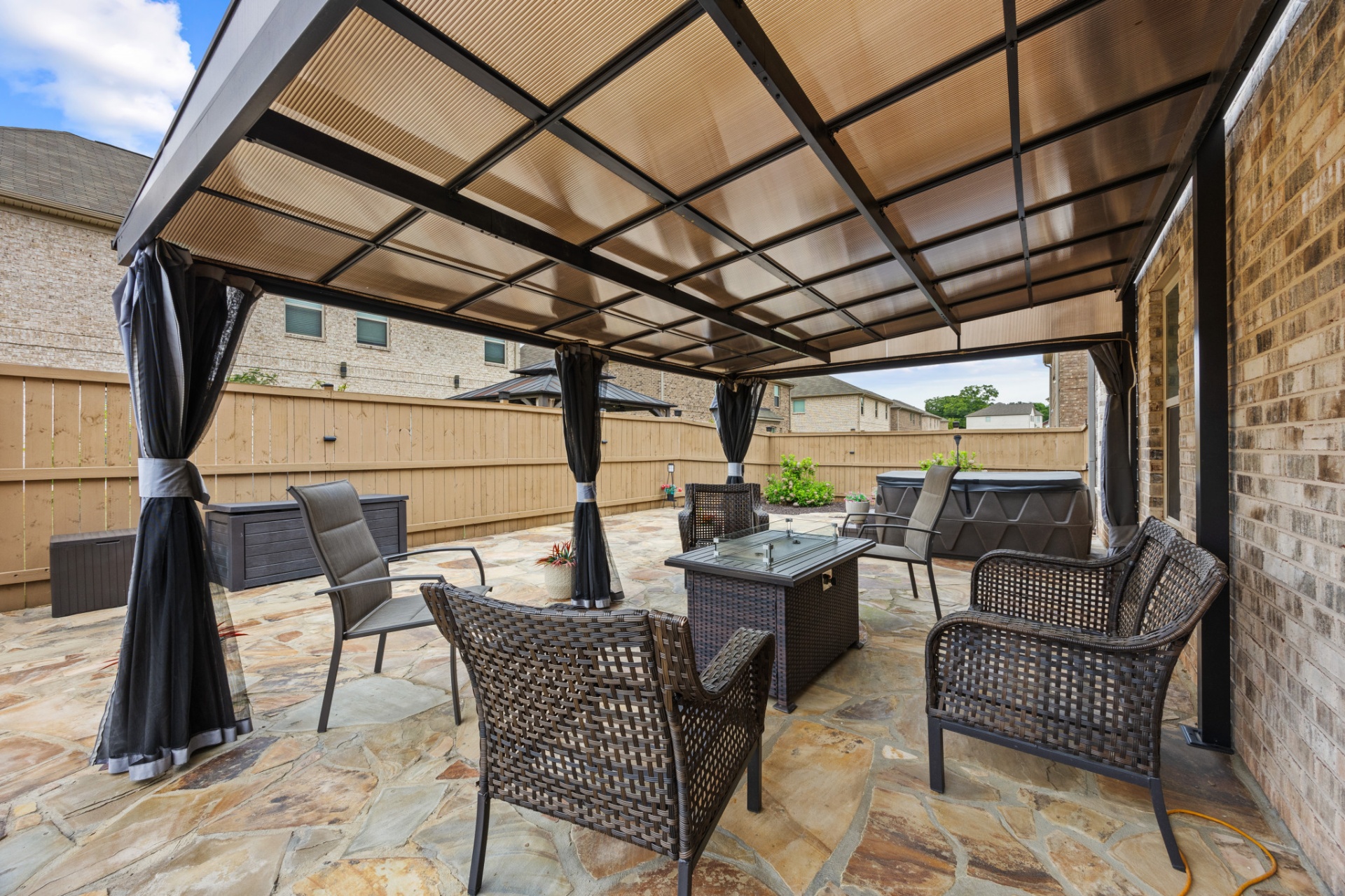 Covered pergola with firepit table and lounge seating